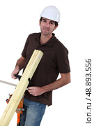 Builder with wood in a vice. Стоковое фото, агентство Ingram Publishing / Фотобанк Лори
