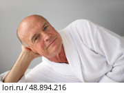 Elderly man lying in his bathrobe. Стоковое фото, агентство Ingram Publishing / Фотобанк Лори