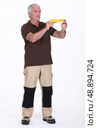 Man holding a try square. Стоковое фото, агентство Ingram Publishing / Фотобанк Лори