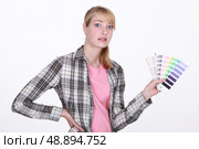 Woman holding up paint samples. Стоковое фото, агентство Ingram Publishing / Фотобанк Лори