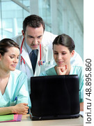 A team of medical professionals consulting patient records. Стоковое фото, агентство Ingram Publishing / Фотобанк Лори