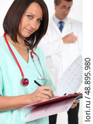 Medical professional filling in a patient record. Стоковое фото, агентство Ingram Publishing / Фотобанк Лори