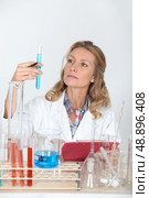 Female lab technician looking at test tubes. Стоковое фото, агентство Ingram Publishing / Фотобанк Лори