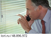 A spy peering through some blinds. Стоковое фото, агентство Ingram Publishing / Фотобанк Лори