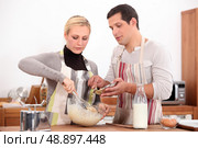Couple making a cake together. Стоковое фото, агентство Ingram Publishing / Фотобанк Лори