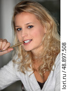 Woman with a pen in her mouth. Стоковое фото, агентство Ingram Publishing / Фотобанк Лори