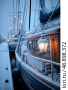 A boat with a light on it is docked in a harbor. Стоковое AI-изображение, AI-художник Ярославский Максим / Фотобанк Лори