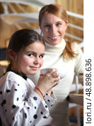 Little girl drinking from large mug at breakfast. Стоковое фото, агентство Ingram Publishing / Фотобанк Лори