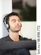 Man listening to music with eyes shut. Стоковое фото, агентство Ingram Publishing / Фотобанк Лори