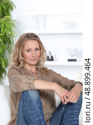 Woman sitting on white sofa. Стоковое фото, агентство Ingram Publishing / Фотобанк Лори