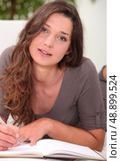 Pretty young woman writing in a book. Стоковое фото, агентство Ingram Publishing / Фотобанк Лори