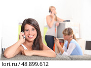 Friends using phones at home. Стоковое фото, агентство Ingram Publishing / Фотобанк Лори