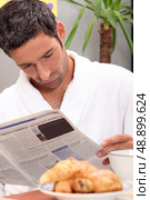 Man reading a journal over breakfast. Стоковое фото, агентство Ingram Publishing / Фотобанк Лори