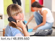 A teenage girl answering the phone at her place. Стоковое фото, агентство Ingram Publishing / Фотобанк Лори