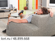 Young man relaxing on sofa. Стоковое фото, агентство Ingram Publishing / Фотобанк Лори