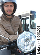 Man on a moped with a bus in the background. Стоковое фото, агентство Ingram Publishing / Фотобанк Лори