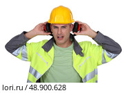 Builder removing earmuffs. Стоковое фото, агентство Ingram Publishing / Фотобанк Лори