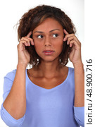 Young woman holding her hands to her head. Стоковое фото, агентство Ingram Publishing / Фотобанк Лори