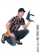 Manual worker kneeling with drill. Стоковое фото, агентство Ingram Publishing / Фотобанк Лори