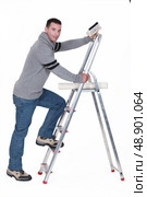 Man putting up wallpaper. Стоковое фото, агентство Ingram Publishing / Фотобанк Лори