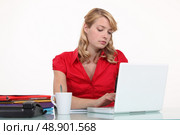 Bored secretary typing on her laptop. Стоковое фото, агентство Ingram Publishing / Фотобанк Лори