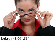Businesswoman peering over her glasses. Стоковое фото, агентство Ingram Publishing / Фотобанк Лори