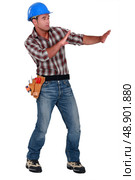 Tradesman trying to protect himself from a shooting object. Стоковое фото, агентство Ingram Publishing / Фотобанк Лори