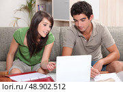 Young couple sitting on a sofa with a laptop. Стоковое фото, агентство Ingram Publishing / Фотобанк Лори