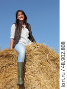 female cultivator posing on hay bale. Стоковое фото, агентство Ingram Publishing / Фотобанк Лори