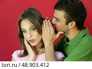Man whispering a secret to a young woman. Стоковое фото, агентство Ingram Publishing / Фотобанк Лори