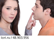 Girlfriend shushing boyfriend. Стоковое фото, агентство Ingram Publishing / Фотобанк Лори