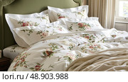 A bed made with a white comforter featuring a green headboard against a neutral wall. Стоковое AI-изображение, AI-художник Данила Большаков / Фотобанк Лори