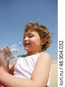 Little kid drinking bottle of water at the beach. Стоковое фото, агентство Ingram Publishing / Фотобанк Лори