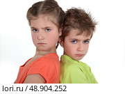 Brother and sister sulking at each other. Стоковое фото, агентство Ingram Publishing / Фотобанк Лори