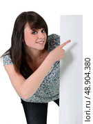 Teenage girl pointing to a white sign. Стоковое фото, агентство Ingram Publishing / Фотобанк Лори
