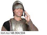 Man wearing armour holding mobile telephone. Стоковое фото, агентство Ingram Publishing / Фотобанк Лори
