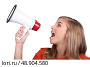 Studio shot of a girl shouting into a megaphone. Стоковое фото, агентство Ingram Publishing / Фотобанк Лори