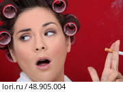 Woman with hair curlers smoking a cigarette. Стоковое фото, агентство Ingram Publishing / Фотобанк Лори