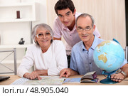 Young man and senior couple seeking a route on a map. Стоковое фото, агентство Ingram Publishing / Фотобанк Лори