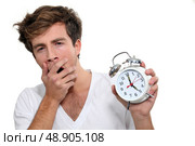 Yawning man holding alarm clock. Стоковое фото, агентство Ingram Publishing / Фотобанк Лори