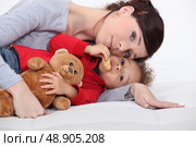 Mother and her adopted son laying on the bed. Стоковое фото, агентство Ingram Publishing / Фотобанк Лори