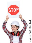 Female builder holding stop sign. Стоковое фото, агентство Ingram Publishing / Фотобанк Лори