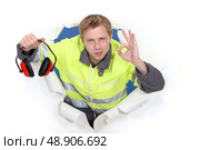 Tradesman promoting the use of earmuffs. Стоковое фото, агентство Ingram Publishing / Фотобанк Лори