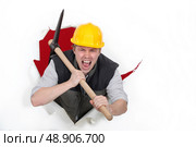 Tradesman bursting through a barrier. Стоковое фото, агентство Ingram Publishing / Фотобанк Лори