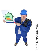 Stern tradesman giving a property an energy efficiency rating of G. Стоковое фото, агентство Ingram Publishing / Фотобанк Лори