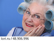 Elderly lady using hair rollers. Стоковое фото, агентство Ingram Publishing / Фотобанк Лори