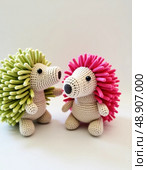 Two adorable knitted hedgehogs sit side by side, showcasing their unique colors Generative AI. Стоковое AI-изображение, AI-художник Юлия Петровская / Фотобанк Лори