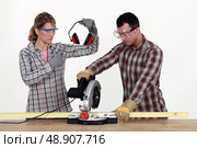Woman making sure man uses hearing protection. Стоковое фото, агентство Ingram Publishing / Фотобанк Лори