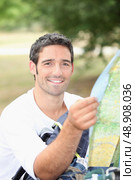 30 years old man watching a map in the forest. Стоковое фото, агентство Ingram Publishing / Фотобанк Лори