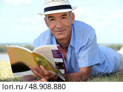 Elderly man reading a book outside. Стоковое фото, агентство Ingram Publishing / Фотобанк Лори